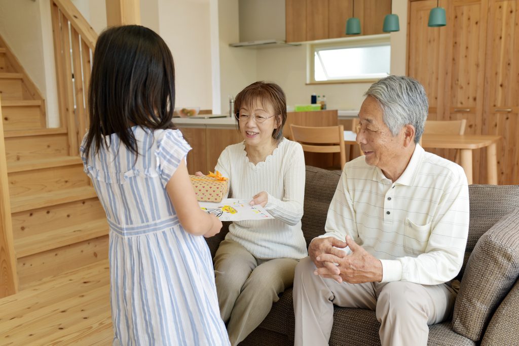 孫が祖父母にプレゼントを渡す